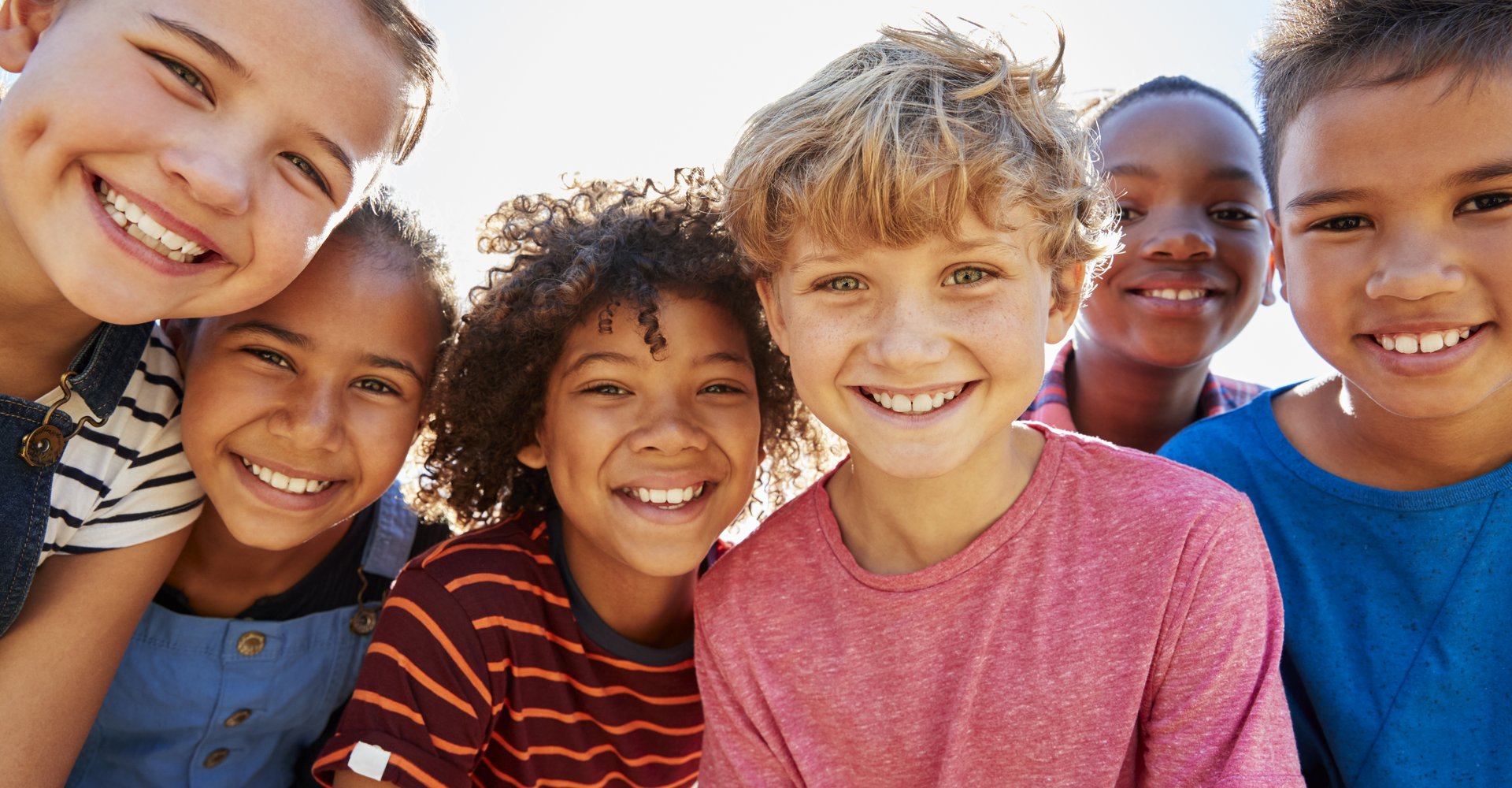 Eine Gruppe von Kindern, die lächelnd den Betrachter anblickt.