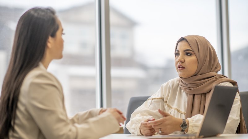 Zwei Frauen am Tisch im Gespräch